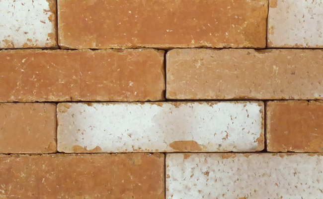 A close-up of Marigold Antique clay pavers from Chelmer Valley, in tones of tan, faded tan, with white